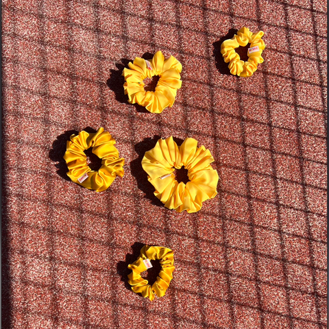 Yellow hair scrunchies on a textured brown surface